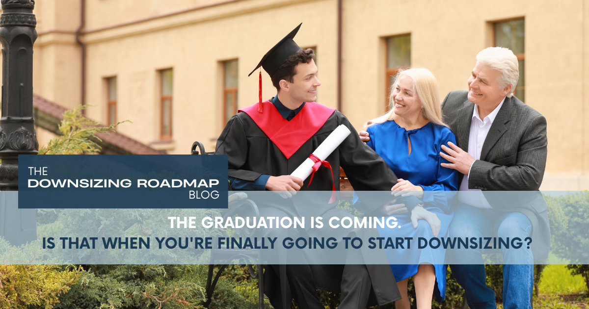 A parent and adult child sitting together at a kitchen table reviewing documents, representing downsizing planning around a child's graduation milestone